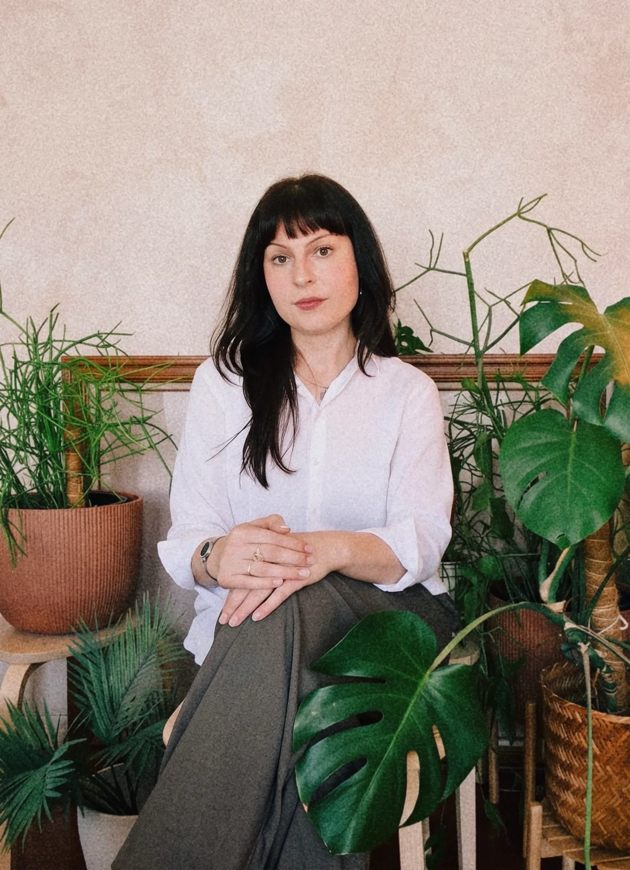 Jordan Navarro, sitting among houseplants in a white shirt